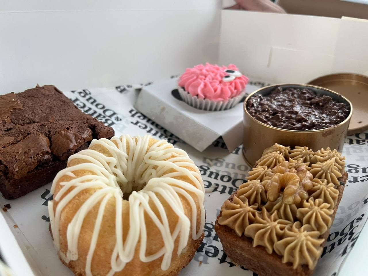 Butter & Dough cakes, brownie and cupcake in an open box